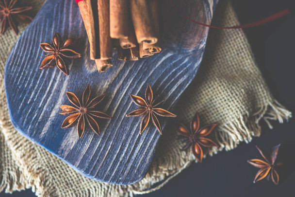 Παραδοσιακές χειμωνιάτικες μπαχαρικά ραβδιά κανέλας και γλυκάνισο αστεριών σε ρουστίκ φόντο με αντίγραφο χώρου - Φωτογραφία, εικόνα