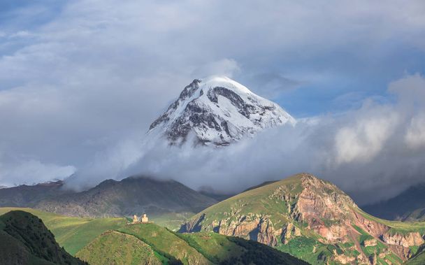 Vista do Monte Kazbek da Igreja da Trindade de Gergeti no verão, Geórgia
 - Foto, Imagem