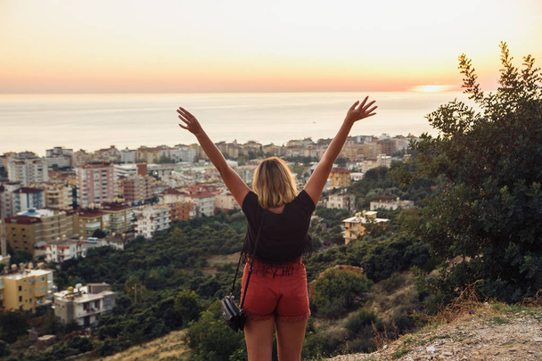 Hiker woman standing with hands up achieving the top. Girl welcomes a sunset. Tourism concept of Alanya, Turkey - Fotoğraf, Görsel