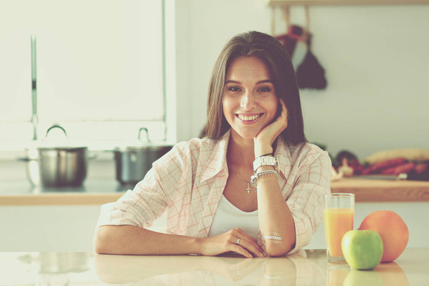 Young woman sitting a table in the kitchen. Young woman - Foto, Imagen