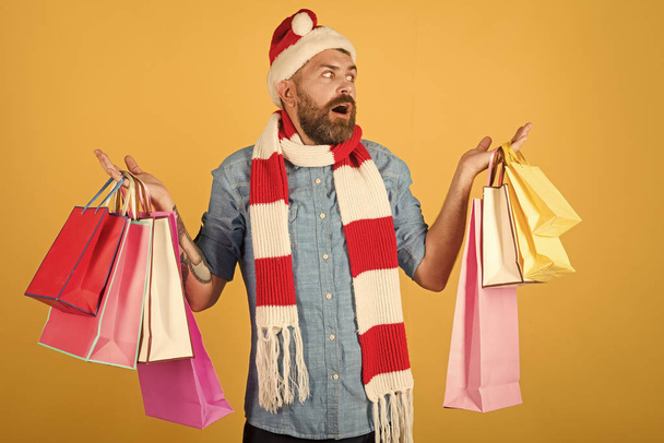 Christmas man shopper hold shopping bags on yellow background - Foto, Imagen