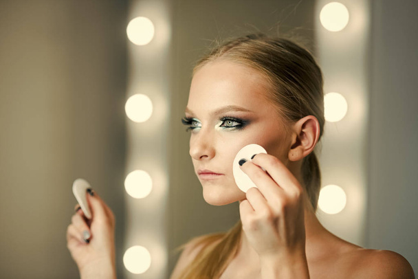 Woman using cotton pad on face for makeup removal - Fotografie, Obrázek