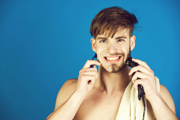 πρόσωπο της χαμογελαστός άνθρωπος στα μαλλιά ξύρισμα με ηλεκτρική ξυριστική μηχανή και ξυράφι ασφάλειας - Φωτογραφία, εικόνα