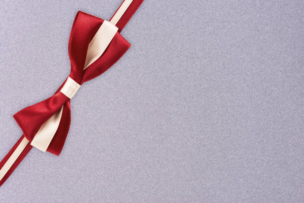 Red and white gift ribbon on a silver textured pattern background. Gift box wrapping concept. - Photo, image