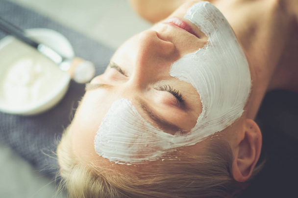 Face mask.Beautiful young girl at spa ,cosmetician woman applying facial mask. - Foto, Imagem