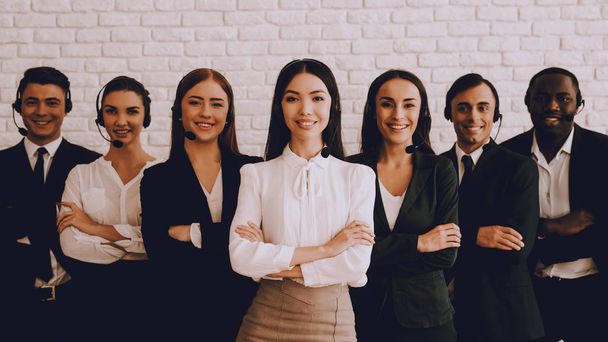 Young Smiling Managers Standing in Modern Office. Training in Office. Modern Office Concept. Smiling Worker. Standing in Room. Woman in White Shirt. Man in Black Suit. White Wall in Office. - Фото, зображення