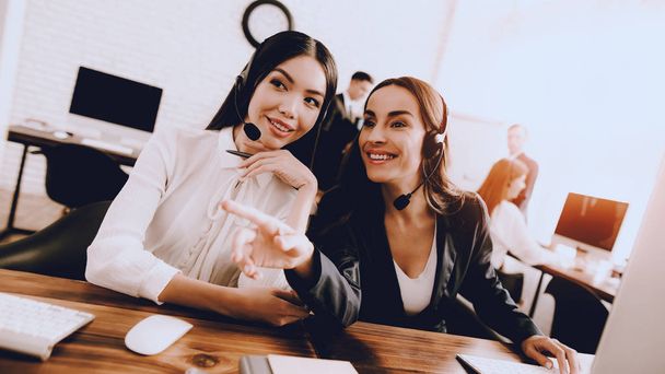 Two Young Smiling Women Working in Call Center. Manager with Computer. Girl on Workplace. Consultant with Microphone. Customer Service Concept. Operator in Office. Smiling Woman in Office. - Фото, зображення