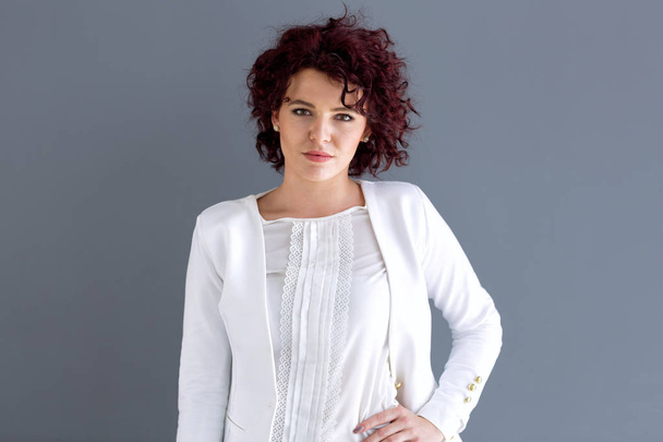 Portrait of attractive curly woman in white suit - Photo, Image