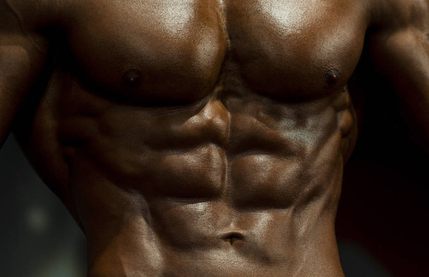 Μοντέλο αρσενικό fitness με γυμνό κορμό δείχνει sixpack κοιλιακό και μυώδες σώμα. Fitness και bodybuilding έννοια. - Φωτογραφία, εικόνα