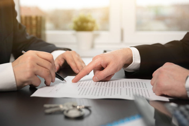 Real estate agent signing a contract buy-sell house. Two men sitting at the desk, home insurance policy on home loans, insurance agent concept - Valokuva, kuva