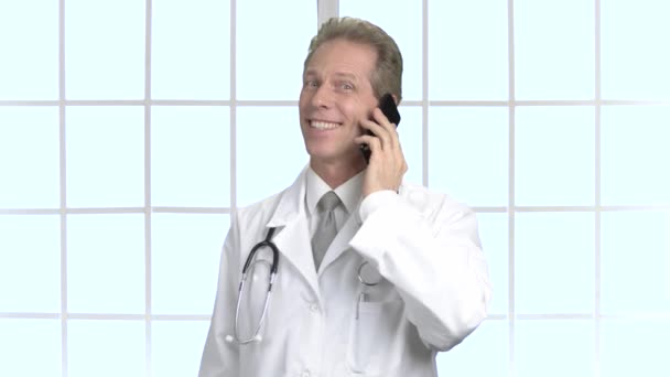 Щасливий лікар середнього віку розмовляє по телефону
. - Кадри, відео