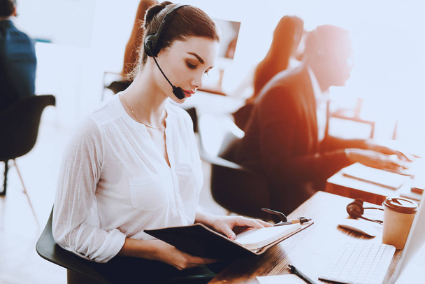 Young Woman Sitting and Working in Call Center. Manager with Computer. Girl on Workplace. Consultant with Microphone. Customer Service Concept. Woman in Headphones. Operator in Office. - Foto, afbeelding