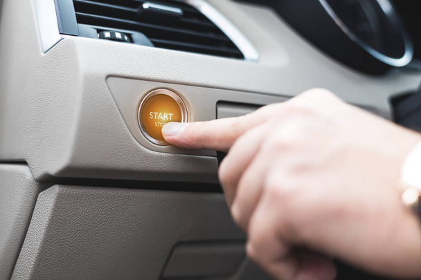 Car start stop system with finger pressing the button, horizontal image - Φωτογραφία, εικόνα