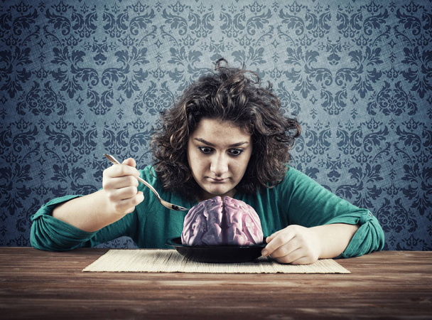 Shocked woman have to eat a brain . The concept of learning very fast. - Photo, Image