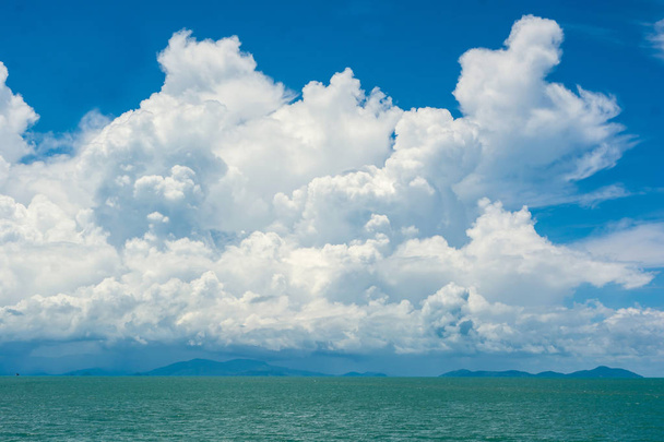 Csodálatos fehér felhő túl napos nap felett sziget és óceán kék ég - Fotó, kép