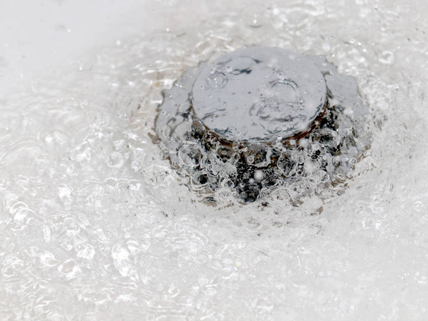 een borrelen met luchtbellen een sterke stroom van water stroomt in het mangat - Foto, afbeelding