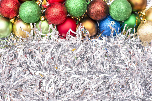 Juguetes de Navidad de colores verde, azul y rojo en el fondo de oropel de plata
 - Foto, imagen