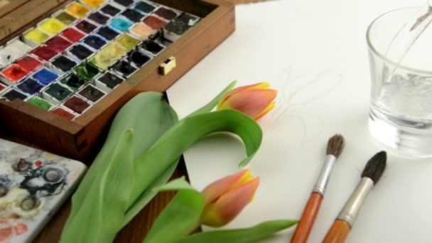 Filling a glass with water to paint tulip in watercolors. - Footage, Video