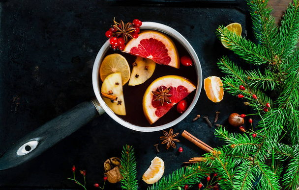 Christmas background. Hot mulled wine with ingredients in authentic ladle on on vintage rusty metal background. The concept of celebration and cooking warming drinks. Top view, close up, copy space - Photo, Image