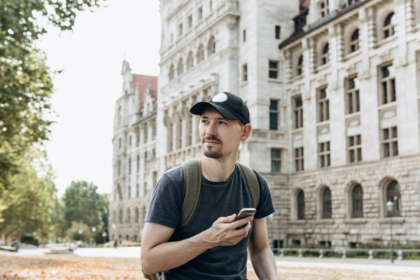 Egy turista férfi vagy fiú, egy hátizsákban használ egy mozgatható telefon - Fotó, kép