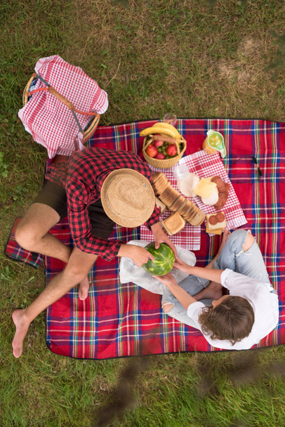 Couple in love enjoying picnic time drink and food in beautiful nature on the river bank top view - Foto, Bild