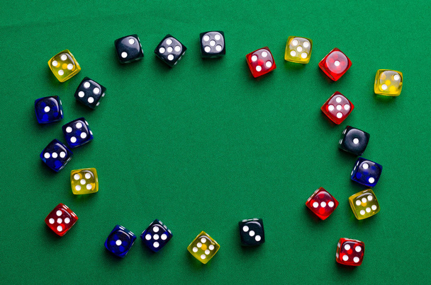 πολύχρωμα ζάρια για επιτραπέζια παιχνίδια σε ένα πράσινο τραπέζι - Φωτογραφία, εικόνα