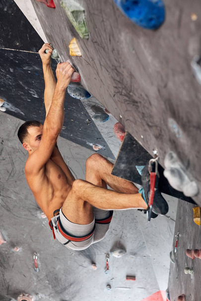 Male professional climber at indoor workout at bouldering centre. - Foto, Bild