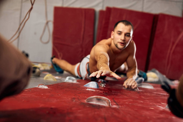Male professional climber at indoor workout at bouldering centre. - Foto, Imagem