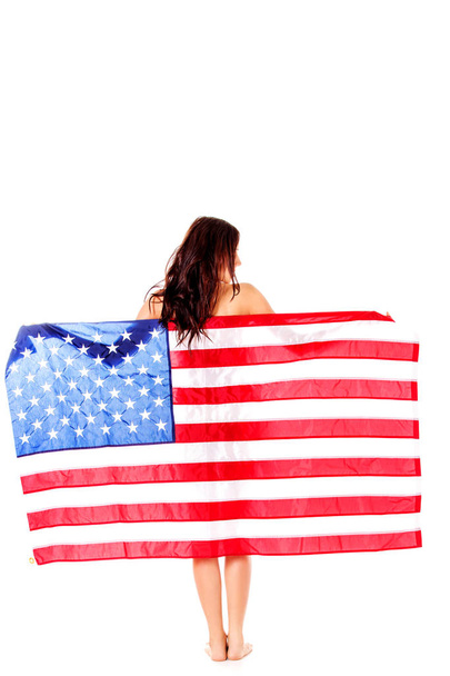 Beautiful brunette woman wrapped into American flag. - Zdjęcie, obraz