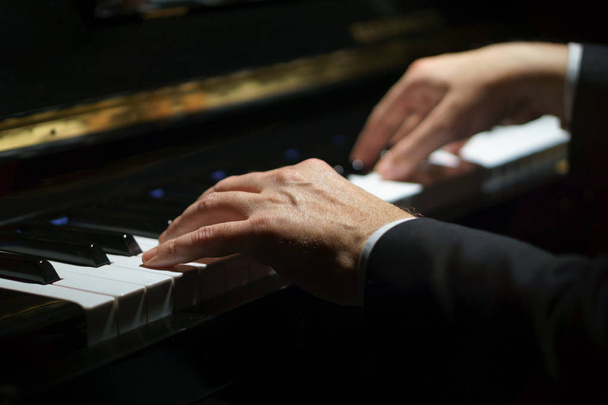 professioneller Musiker Pianist greift in Klaviertasten eines klassischen Klaviers. - Foto, Bild