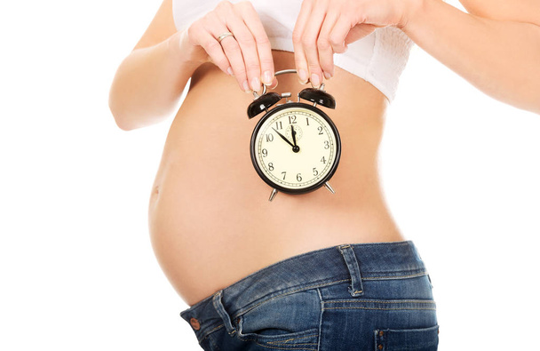 Pregnant woman with an alarm clock - Zdjęcie, obraz
