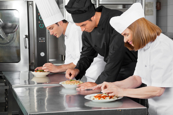 Chefs Garnishing Dishes On Counter - Zdjęcie, obraz