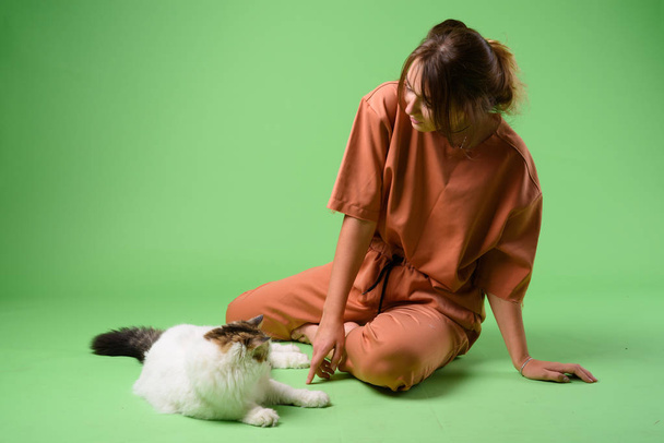 Studio shot of young beautiful woman with Persian cat - Foto, afbeelding