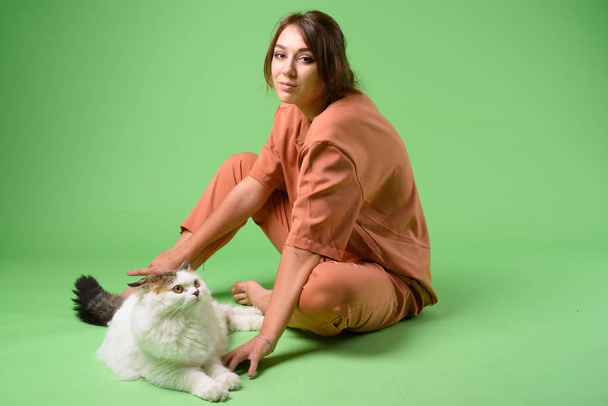 Studio shot of young beautiful woman with Persian cat - Fotoğraf, Görsel