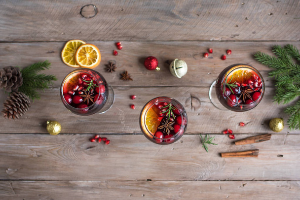 Christmas sangria or Mulled wine with oranges, pomegranate seeds, cranberry, rosemary and spices - homemade festive drink for Christmas time. - Foto, Imagem