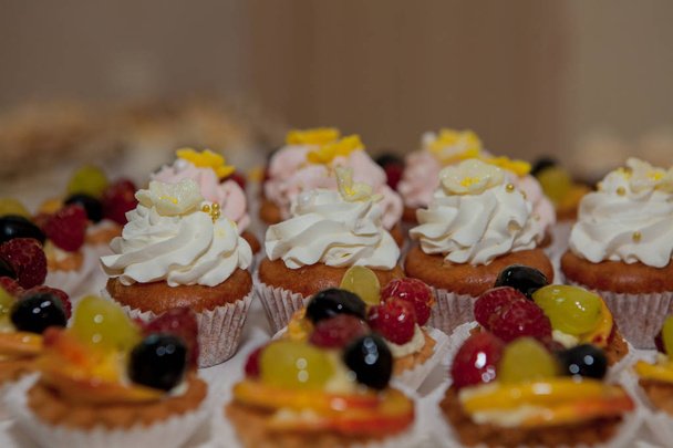 cupcakes with raspberries, grapes and peach on a wedding table. - Fotografie, Obrázek