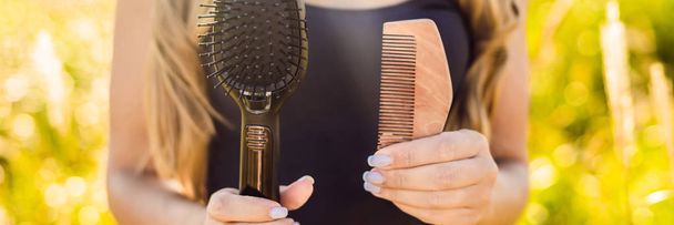 Zero waste concept. Woman holding wooden comb and plastic comb. - Фото, зображення