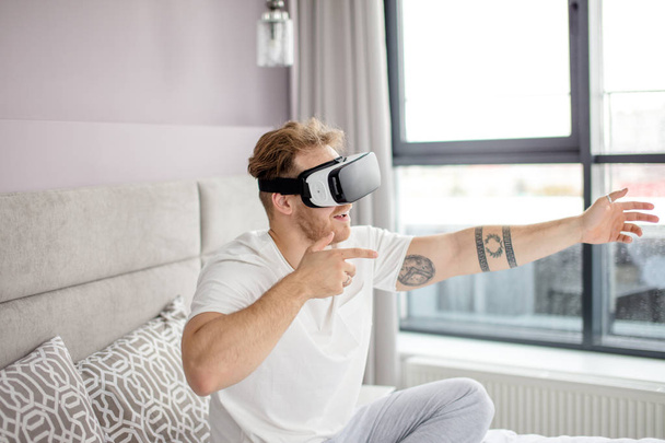 active positive guy wearing vVR glasses - Fotó, kép