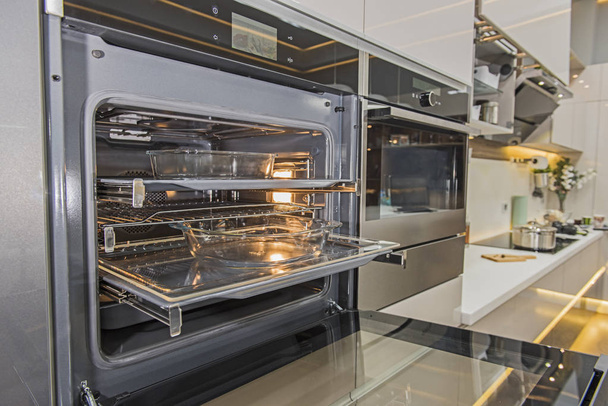 Wnętrz wystrój wyświetlone jest nowoczesna kuchnia piekarnik kuchenka urządzenia w luksusowy apartament showroom - Zdjęcie, obraz