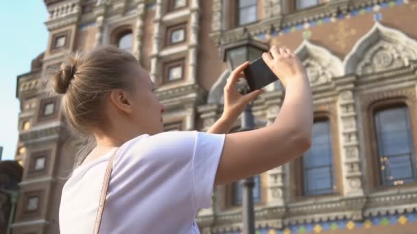Woman taking pictures of Church of the Savior on Blood with smartphone. - Footage, Video