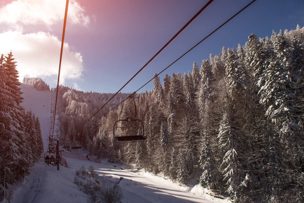 Krajina na lyžařský vlek v horách na zasněžený den při západu slunce - Fotografie, Obrázek