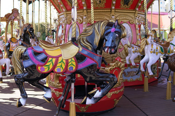 Carrusel para niños con atracciones de caballos en el Parque
 - Foto, imagen