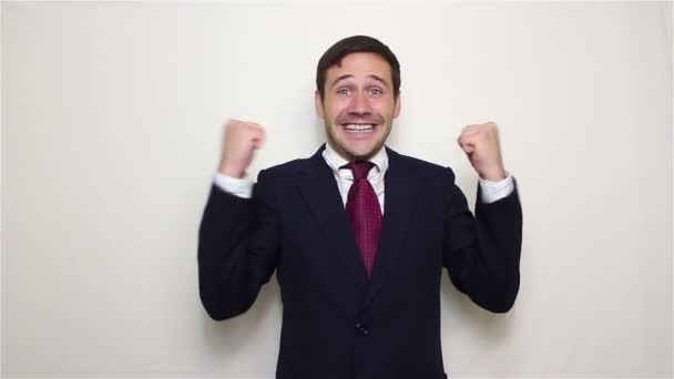 Handsome young businessman actively expresses joy clapping and loud laughing - Imágenes, Vídeo