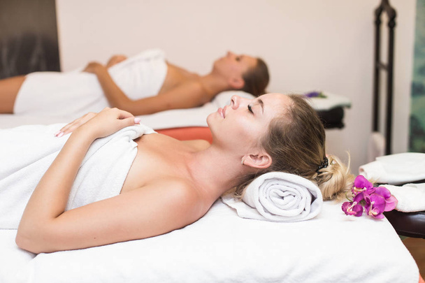 Two cute young women enjoying during a skin care treatment at a spa. massage and beauty treatments in the beauty salon - Fotografie, Obrázek