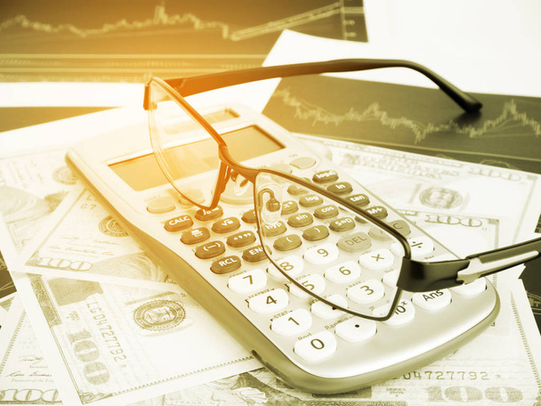 Kalkulačka a brýle s obchodní grafy a sestavy informací pozadím pro finanční a ekonomické pojmy, Vintage tón. - Fotografie, Obrázek