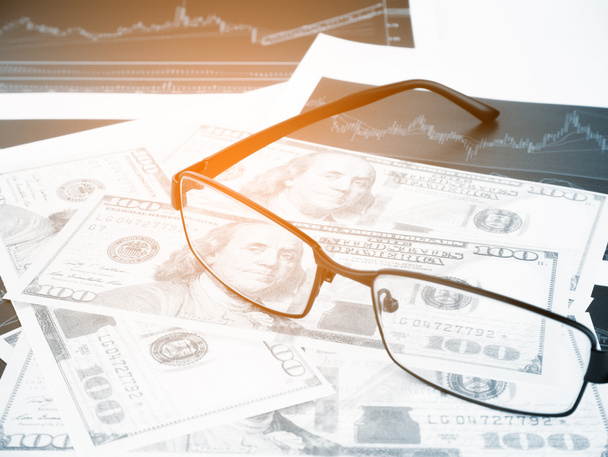 Glasses with business graphs and report information background for financial and economy concepts, Blue tone. - Photo, Image