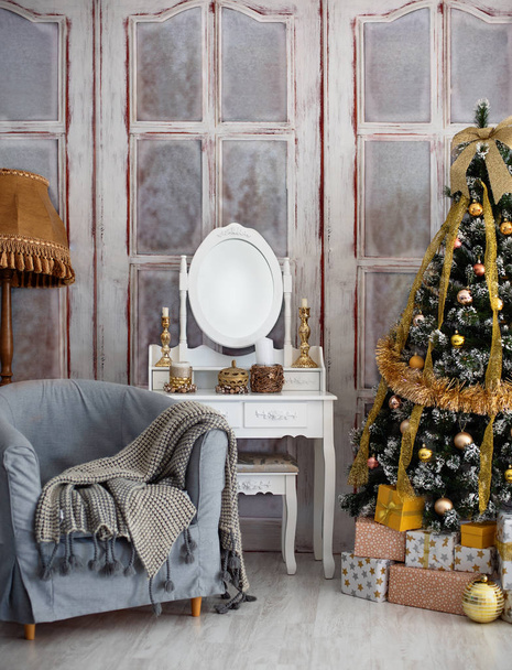 Room with a Christmas tree and a table with a mirror. - 写真・画像