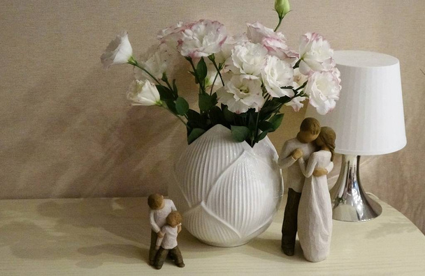 親と子の感動の木製フィギュアに近い花の花束。パステル トーンのイメージ. - 写真・画像