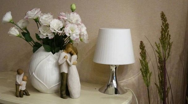 Touching Wooden figures of parents and children near a bouquet of flowers. The image in pastel tones. - Photo, Image