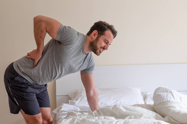 Man waking up in the morning and suffer for back pain - Fotó, kép